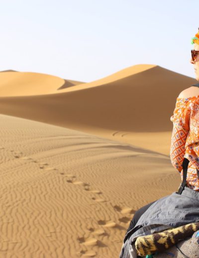woman riding animal on dessert